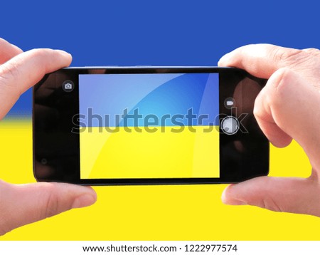 The concept of tourism and travel. The hands of men make a telephone photograph of the flag of Ukraine. On the smartphone close-up image of the flag. Photos for social networks, blogs, instagram.