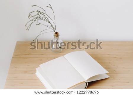 wooden desk with book and flowers. Flat lay, top view.