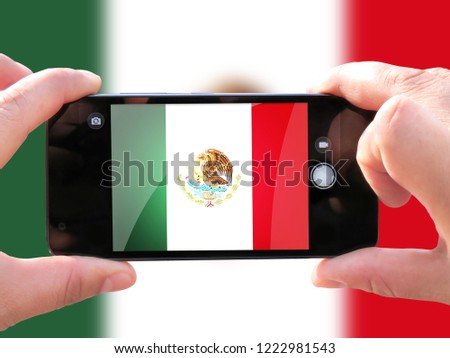The concept of tourism and travel. The hands of men make a telephone photograph of the flag of Mexico. On the smartphone close-up image of the flag. Photos for social networks, blogs, instagram.