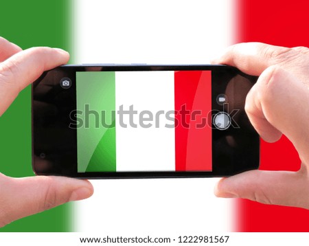 The concept of tourism and travel. The hands of men make a telephone photograph of the flag of Italy. On the smartphone close-up image of the flag. Photos for social networks, blogs, instagram.