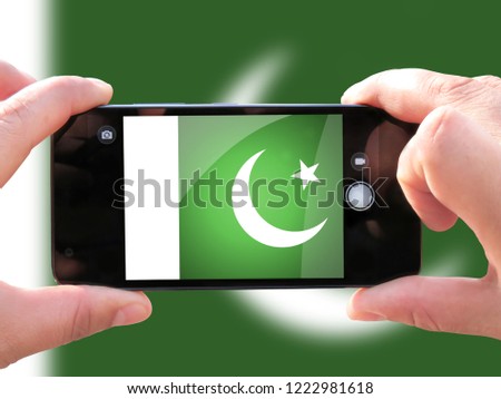 The concept of tourism and travel. The hands of men make a telephone photograph of the flag of Pakistan. On the smartphone close-up image of the flag. Photos for social networks, blogs, instagram.