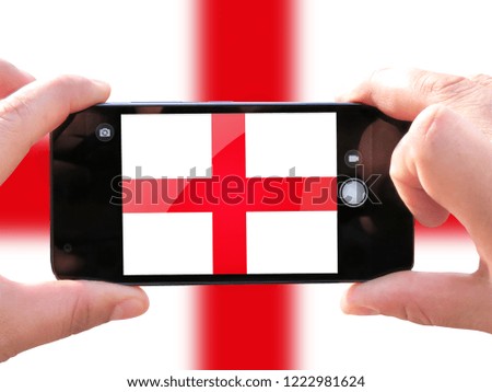 The concept of tourism and travel. The hands of men make a telephone photograph of the flag of England. On the smartphone close-up image of the flag. Photos for social networks, blogs, instagram.