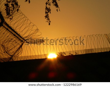 Evening sun at the prison with barbed wire