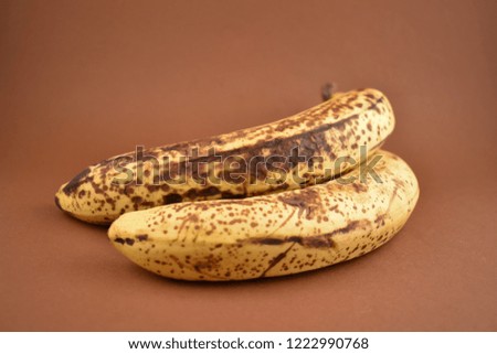 Ripe banana stock images. Brown banana on a brown background. Overripe banana images