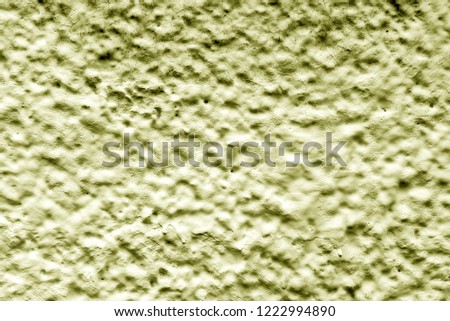 Yellow relief wall of the house. Texture background finishing the old Soviet house. Dirty shabby wall with putty. Relief texture of yellow color. View of the lunar craters from a bird's-eye view.