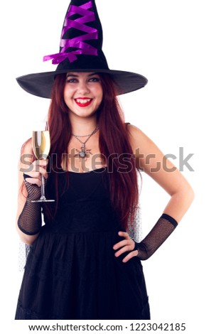 Photo of laughing witch in black hat, with glass of champagne