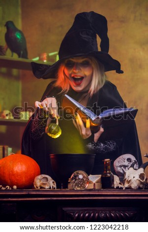Image of witch reading spell pumpkin in hand