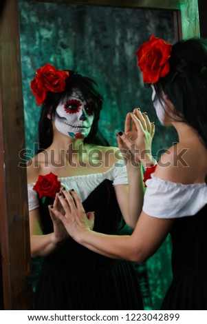 Photo of witch girl with white face and red flower on her head