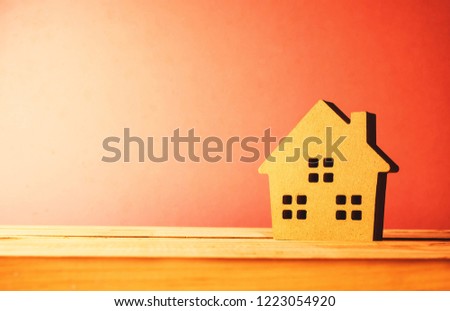 model house on green grass pink background copy space