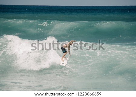 Blond guy surfing at Banzai pipeline Beach, North Shore Oahu