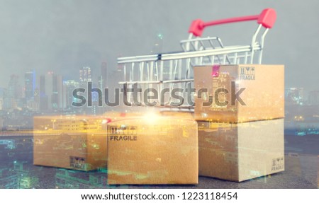 Double exposure of Paper shopping boxs  and a shopping cart on city night background.shopping online and delivery service concept.