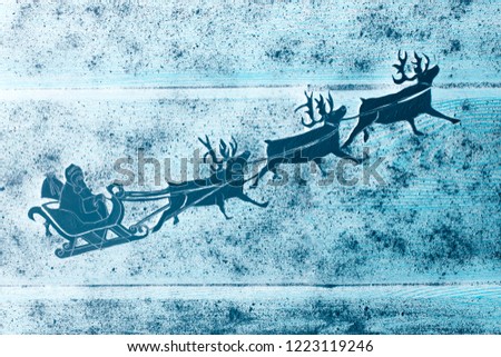 Santa Claus sleigh with north deers, Santa ride in the sky with presents in bag. Traditional Christmas New Year home wall decoration. Winter holiday background. Paper carving art
