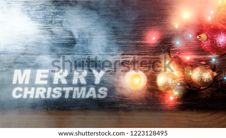 Merry Christmas greeting with colorful christmas light, balls and candle on the table