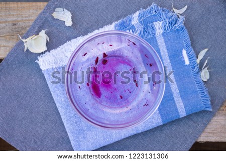 Unclean, dirty glass bowl on table and napkin with pieces of food and traces of sauces left after having food - lunch, dinner or breakfast and needed to be washed or clean up. Kitchenware concept.