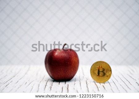 Digital currency physical gold bitcoin coin near apple. Selective focus with copy space for text.