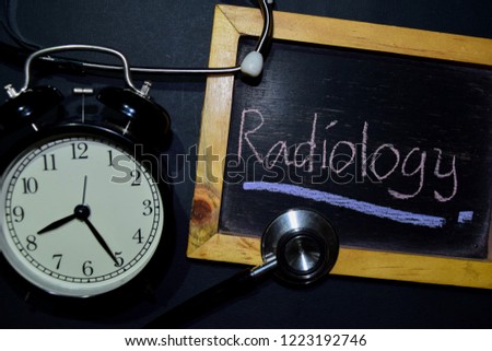 The words Radiology handwriting on chalkboard on top view. Alarm clock, stethoscope on black background. With education, medical and health concepts