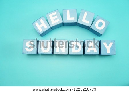 hello sunday with blue wooden cubes alphabet letter on blue background
