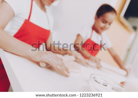 Beautiful Arms Rolling Dough. Happy Girl with Happy Mom on Kitchen. Apron on Girl and Woman. Smile Girl Tries Rolling Dough. Happy Time With Mom. Preparation Dough for Cook. Happy Smile on Face Girl.