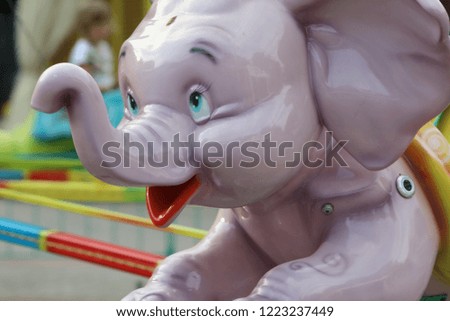 elephant carousel of pink, green, blue colour, happy elephants