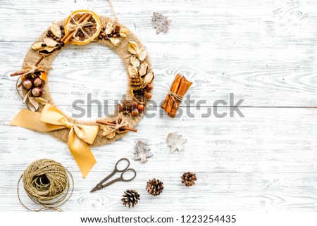 Preparing to Christmas. Creative christmas wreath made of thread near decorative elements on white wooden background top view copy space