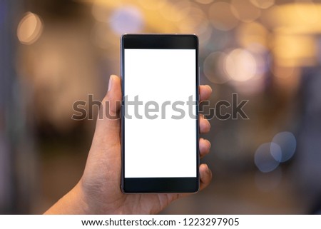 Man holding smartphone with blank screen at shopping mall. Take your screen to put on advertising. Royalty-Free Stock Photo #1223297905