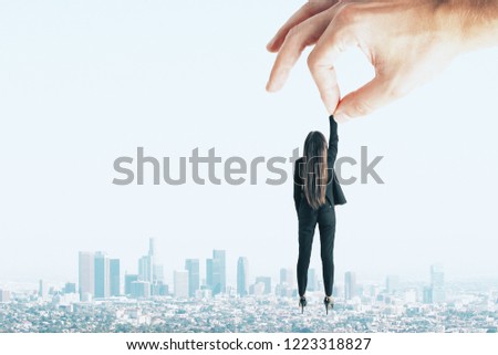 Teamwork and supervision concept. Hand holding businesswoman on sky and city background