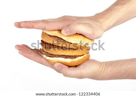 Image of a human's hand pressing a ready-to-eat hamburger on a white background
