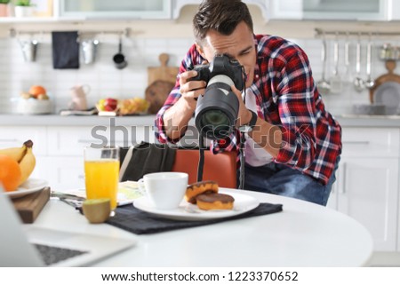 Food blogger taking photo of breakfast in kitchen