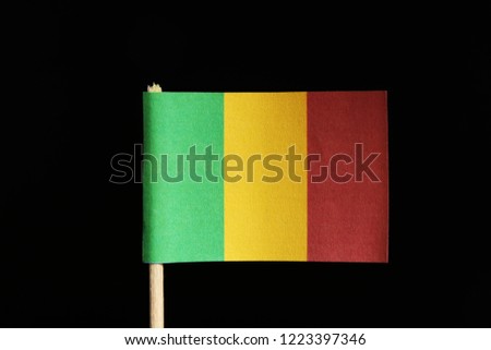 A official and original flag of Mali on toothpick on black background. Consists of a vertical tricolour of green, gold and red