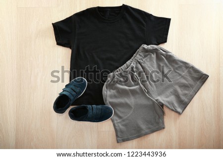 Stylish outfit with shoes on wooden background