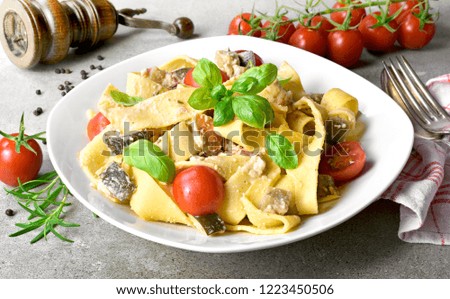 Delicious pasta dish with ricotta sauce and fresh herbs. Tagliatelle noodles on a white plate, italian cuisine. Top view or high angle shot.