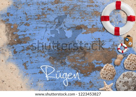 Maritime decoration and the shape of the island "Rügen" on blue wooden background