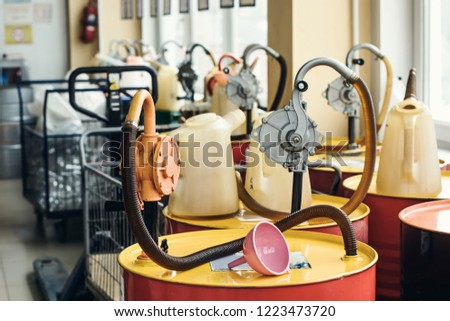 Motor oil in barrels with pump indoors with copy space. Store of lube. Product for bottling close up. Maintenance. Warehouse inside. Background of automotive shop. Auto service. Change of oil.