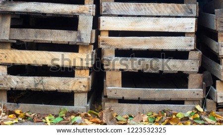 a stack of empty wooden boxes stand on the ground