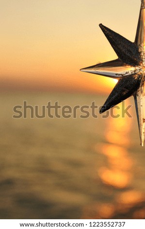 Christmas decoration star on the background of the sunset on the sea. Vertical
