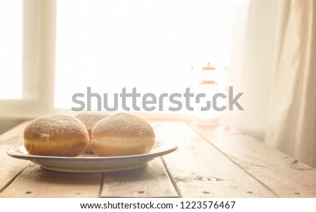 Still life for jewish holiday Hanukkah with Donuts on the Plate, Rustic wooden table with Window backlight.Shallow DOF.Shallow DOF.Hanukkah celebration concept.