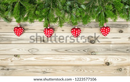 Christmas tree branches with red hearts ornaments decoration. Winter holidays background
