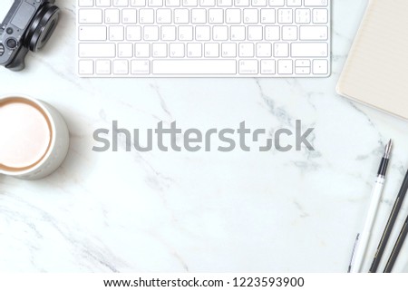 Marble study desk with keyboard, pen tablet, coffee and camera