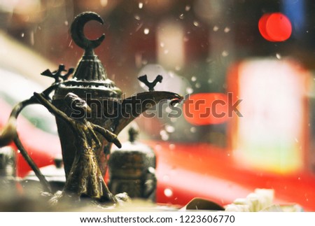 Deatiol of statue of traditional turkish dervish dancer and turkish half moon on the table in the street during the rain, Turkey