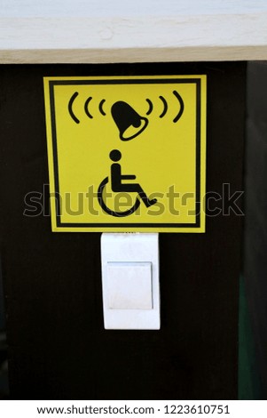 Sign and doorbell for disabled entrance on the black wall. Sign and symbol concept.