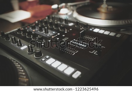 Dj sound mixer and turntables with vinyl records. Professional disc jockey audio equipment. Modern audio mixing controller with volume faders and push buttons