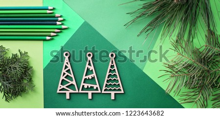Tree simple wooden trees and many various shade of green color pencils lay on the green color gradation paper background, branches of different fir trees, original craft, diy concept for kid, banner