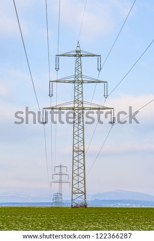 acres with snow in winter in beautiful light with electricity tower