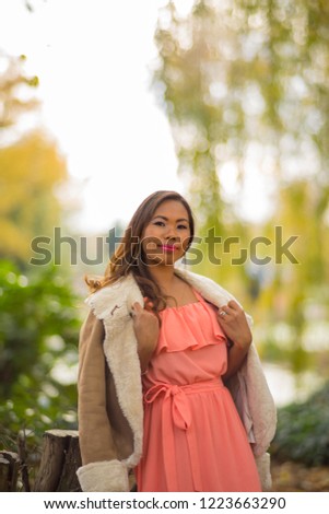 Southeast Asian female model hangs out in a park at Autumn time