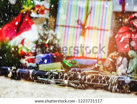 Close up of clarinet over Christmas tree and gift boxes greeting season decoration with snowfall, Christmas background
