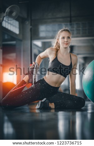 Young attractive woman fitness doing exercises workout with ball in gym. Woman stretching the muscles and relaxing after exercise at fitness gym club. Royalty-Free Stock Photo #1223736715