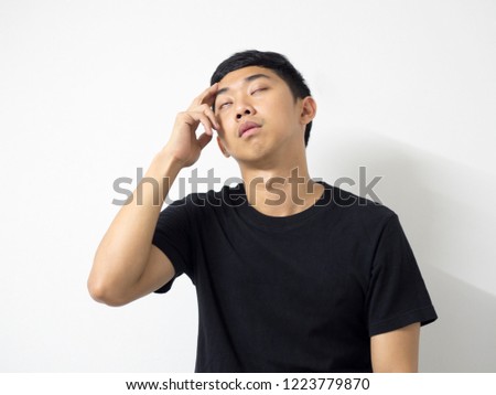 Young Asian man black shirt touch at the eyebrow with close his eyes feel bored and headache in white isolate background.