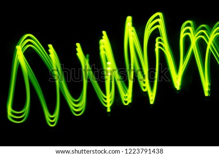 abstract image of Of the light,green light painting photography, long exposure waves and curves against a black background