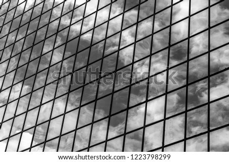 Clouds reflecting in a skyscraper windows in a commercial building. Modern architecture. Black and white photography