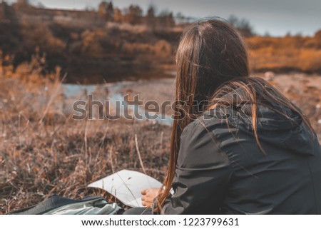 young girl draws autumn landscape